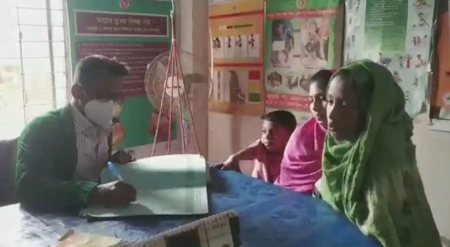 একজন স্বাস্থ্যকর্মী রোগীর সাথে আলোচনা করছেন, স্বাস্থ্যসেবা কেন্দ্রের ভিতরে।. Channel i News - চ্যানেল আই নিউজ