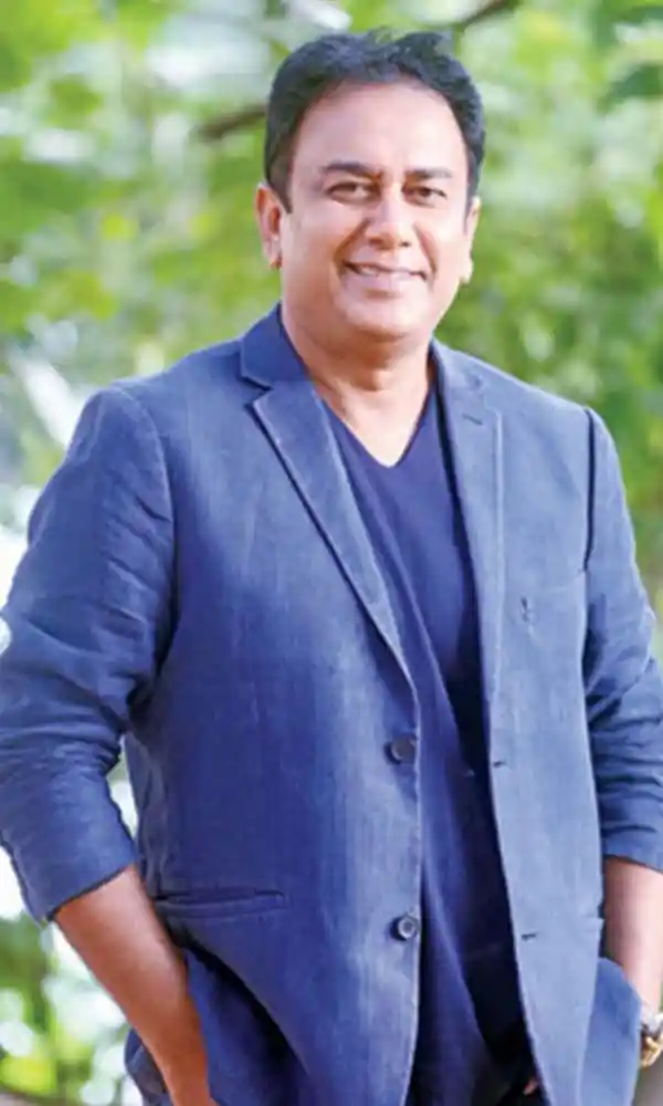 ফেরদৌস ওয়াহিদ হাসিমুখে, কালো শার্ট পরা, চুলে সাদা দাগ. Channel i News - চ্যানেল আই নিউজ