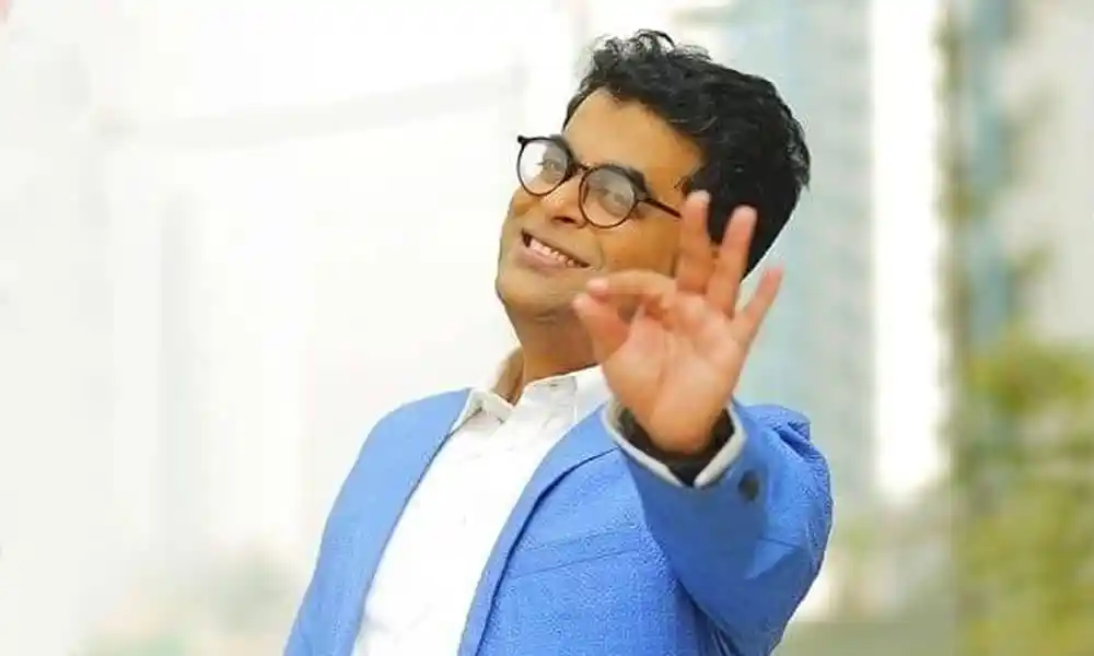 বিপ্লব সাহা হাসিমুখে হাতের ইশারায় শুভেচ্ছা জানাচ্ছেন. Channel i News - চ্যানেল আই নিউজ
