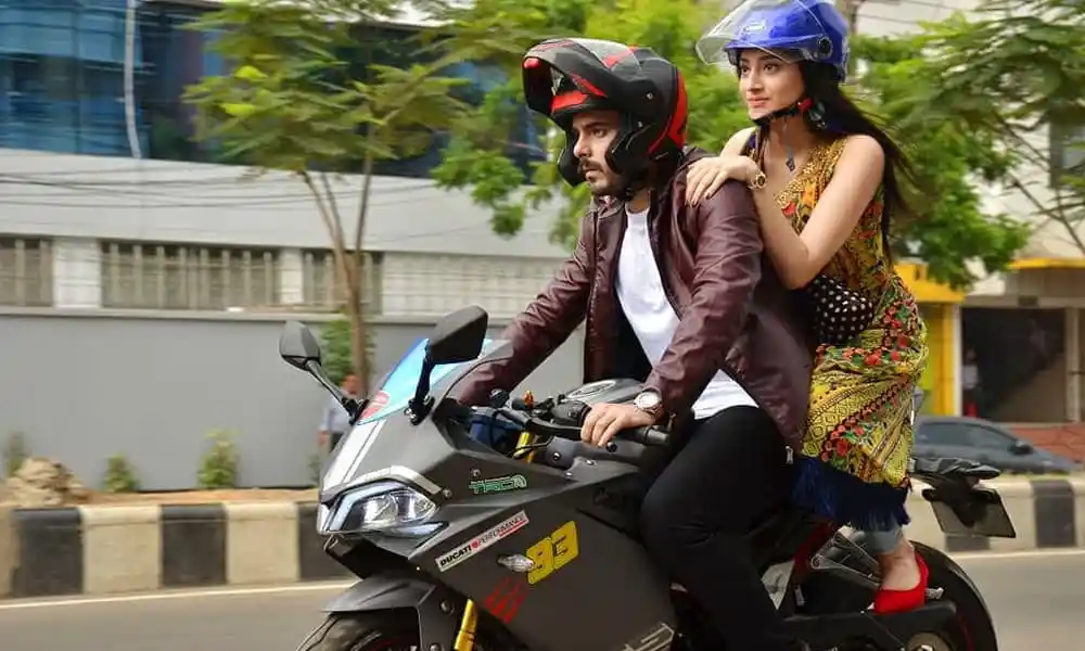 দুটি মানুষ বাইকে চড়ে শহরের রাস্তায় চলাচল করছে. Channel i News - চ্যানেল আই নিউজ