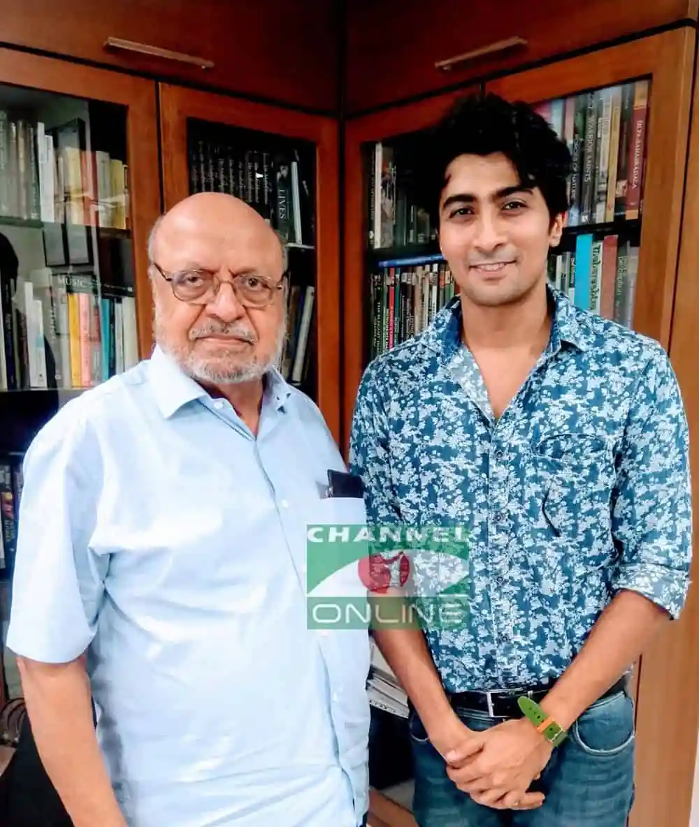 দুইজন পুরুষ, একজন বৃদ্ধ ও একজন যুবক, বইয়ের ক্যাবিনেটের সামনে দাঁড়িয়ে. Channel i News - চ্যানেল আই নিউজ