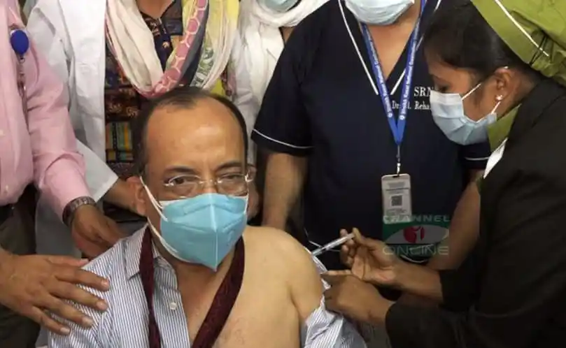 বাংলাদেশের একজন ব্যক্তি করোনাভাইরাসের টিকা নিচ্ছেন, স্বাস্থ্যকর্মী সহায়তা করছেন. Channel i News - চ্যানেল আই নিউজ