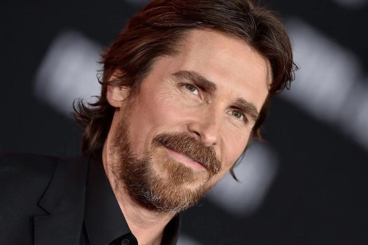 Man with brown hair and beard smiling in a black suit. Channel i News - চ্যানেল আই নিউজ
