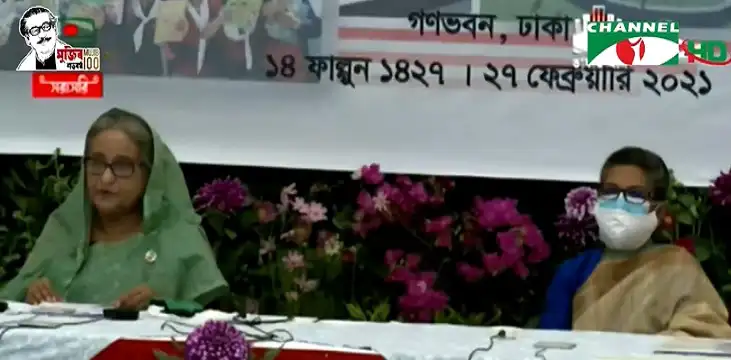 প্রধানমন্ত্রী ও একজন নারী অতিথি আলোচনা করছেন, মুখে মাস্ক পরা. Channel i News - চ্যানেল আই নিউজ