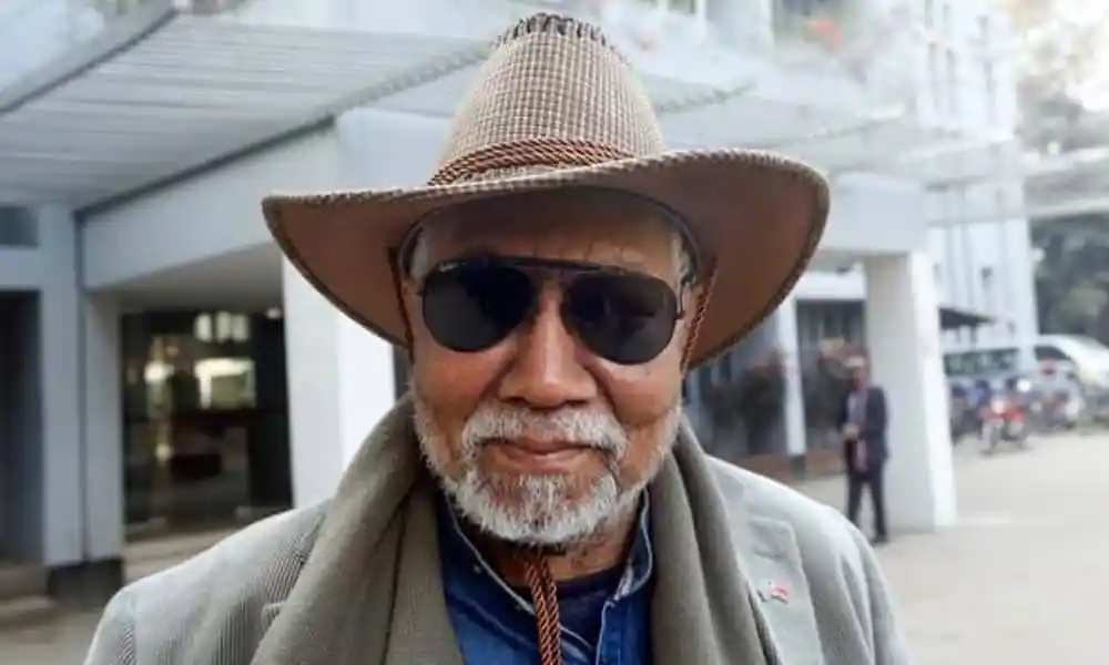 বয়স্ক ব্যক্তি, চশমা ও টুপি পরিহিত, স্মরণ অনুষ্ঠানে অংশগ্রহণ করছেন. Channel i News - চ্যানেল আই নিউজ