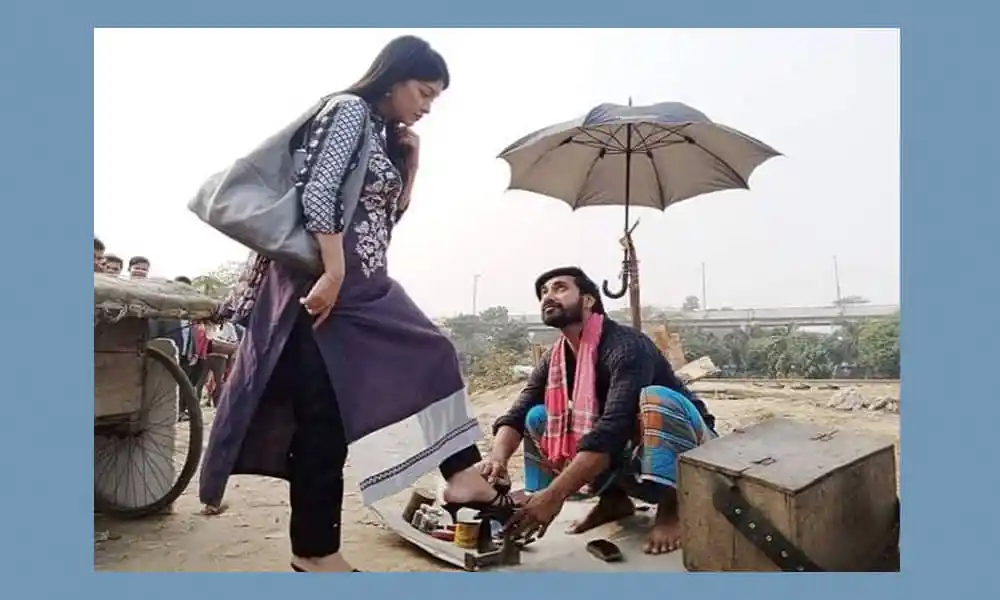 বাজারে জুতা বিক্রি করছেন একজন বিক্রেতা, একজন ক্রেতা তার জুতা দেখছেন. Channel i News - চ্যানেল আই নিউজ
