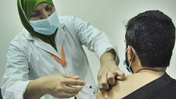 একজন নার্স করোনাভাইরাসের টিকা দিচ্ছেন একজন ব্যক্তিকে. Channel i News - চ্যানেল আই নিউজ