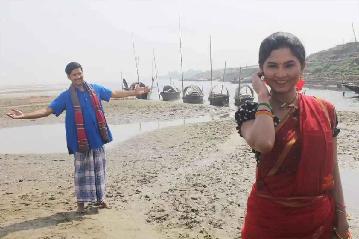 নদীর তীরে দুই ব্যক্তি হাসিমুখে ছবি তুলছেন. Channel i News - চ্যানেল আই নিউজ