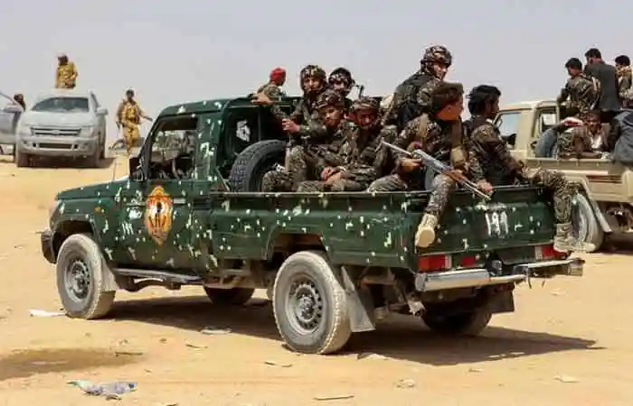 Armed soldiers in a pickup truck in desert terrain. Channel i News - চ্যানেল আই নিউজ