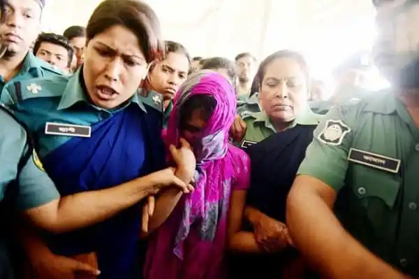 অভিযুক্ত ঐশীকে আদালতে দেখা যাচ্ছে, তার পাশে আইনজীবী ও পুলিশ সদস্যরা. Channel i News - চ্যানেল আই নিউজ