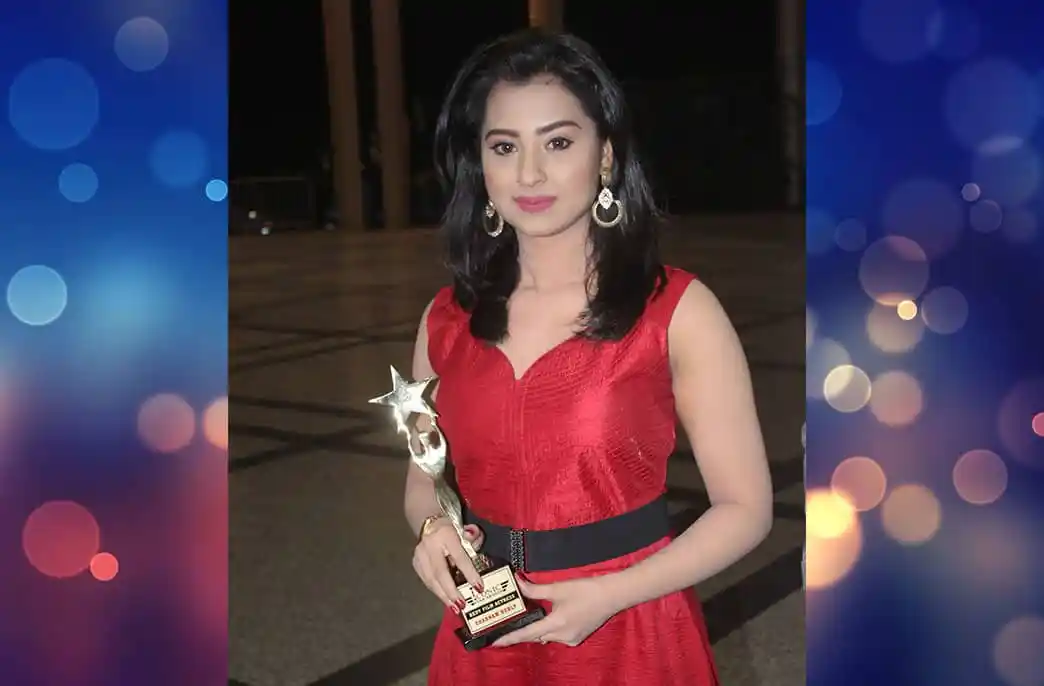 বাংলাদেশি নারী পুরস্কার গ্রহণ করছেন, লাল পোশাক পরা. Channel i News - চ্যানেল আই নিউজ