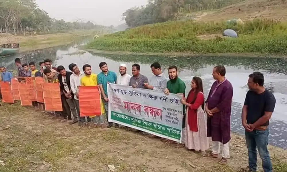 নদী রক্ষায় মানববন্ধনে অংশগ্রহণকারীরা দাঁড়িয়ে আছেন. Channel i News - চ্যানেল আই নিউজ