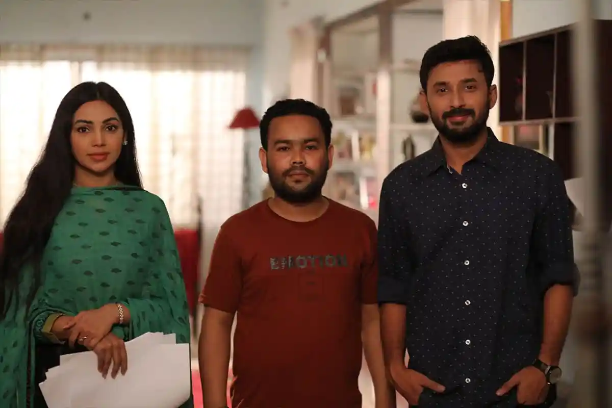 তিনজন ব্যক্তি একটি ঘরে দাঁড়িয়ে, এক নারী ও দুই পুরুষ, বাংলাদেশি পত্রিকা প্রতিবেদনের জন্য ছবি. Channel i News - চ্যানেল আই নিউজ