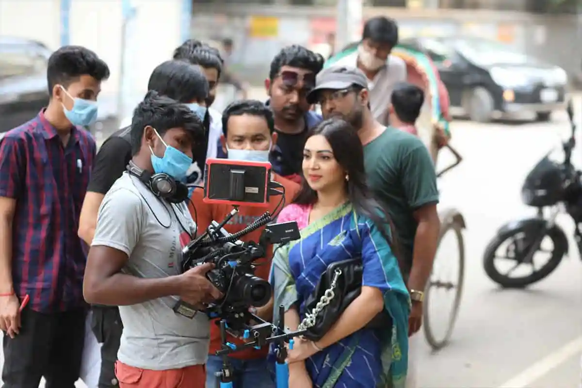 প্রভার সঙ্গে মনোজ প্রামাণিকের শুটিং সেটের ছবি, ক্যামেরার সামনে দাঁড়িয়ে. Channel i News - চ্যানেল আই নিউজ