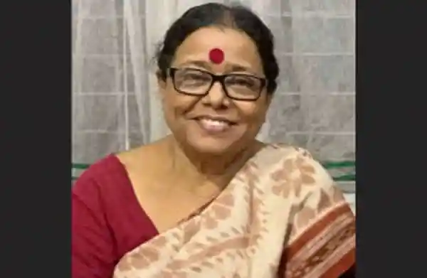 প্রসন্ন মহিলা হাসিমুখে, চশমা ও লাল টিপ পরা. Channel i News - চ্যানেল আই নিউজ