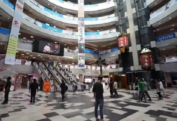 Bangladesh shopping mall interior with escalators and shoppers. Channel i News - চ্যানেল আই নিউজ