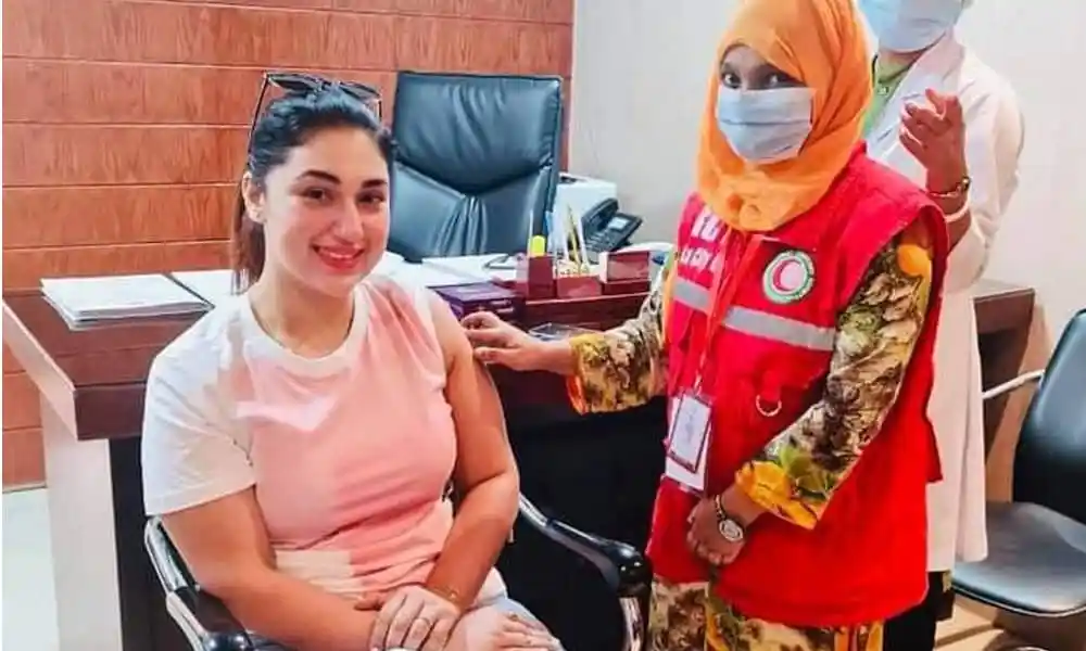 অপু বিশ্বাসের করোনা টিকা নেওয়ার ছবি, স্বাস্থ্যকর্মী সহায়তা করছেন. Channel i News - চ্যানেল আই নিউজ