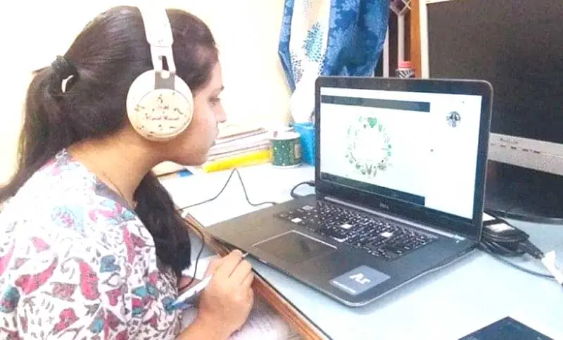 শিক্ষার্থী হেডফোন পরে ল্যাপটপে অনলাইন ক্লাস করছে. Channel i News - চ্যানেল আই নিউজ