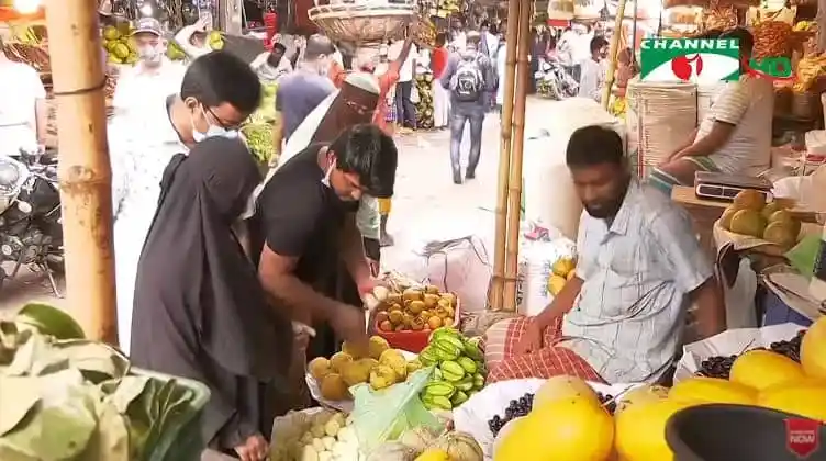 বাজারে ফল বিক্রেতারা ফল বিক্রি করছেন, ক্রেতারা কিনছেন. Channel i News - চ্যানেল আই নিউজ