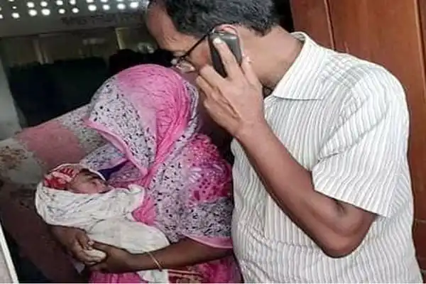 নবজাতককে কোলে নিয়ে ফোনে কথা বলছেন মা ও বাবা. Channel i News - চ্যানেল আই নিউজ