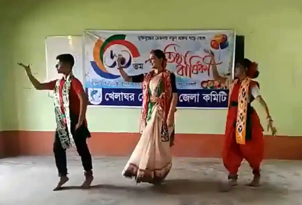 তিনজন শিশু নাচের পারফরম্যান্স করছে, পেছনে ব্যানার দেখা যাচ্ছে. Channel i News - চ্যানেল আই নিউজ