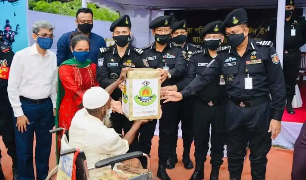 র‌্যাব সদস্যরা অসহায় পরিবারের মাঝে ত্রাণ বিতরণ করছে. Channel i News - চ্যানেল আই নিউজ
