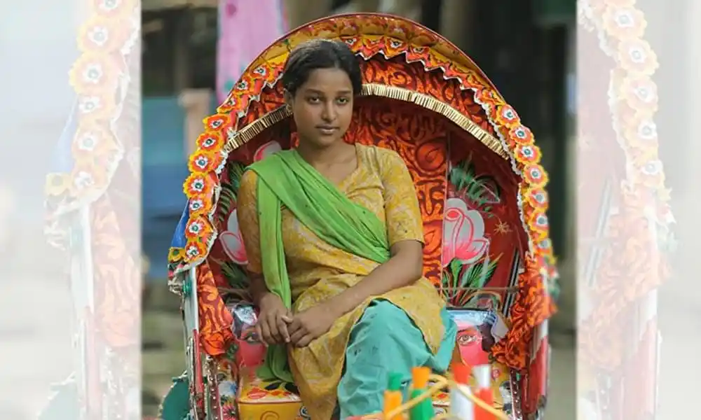 একজন তরুণী রিক্সা গার্লের সাজে বসে আছেন, বাংলার ঐতিহ্যবাহী পোশাক পরা. Channel i News - চ্যানেল আই নিউজ
