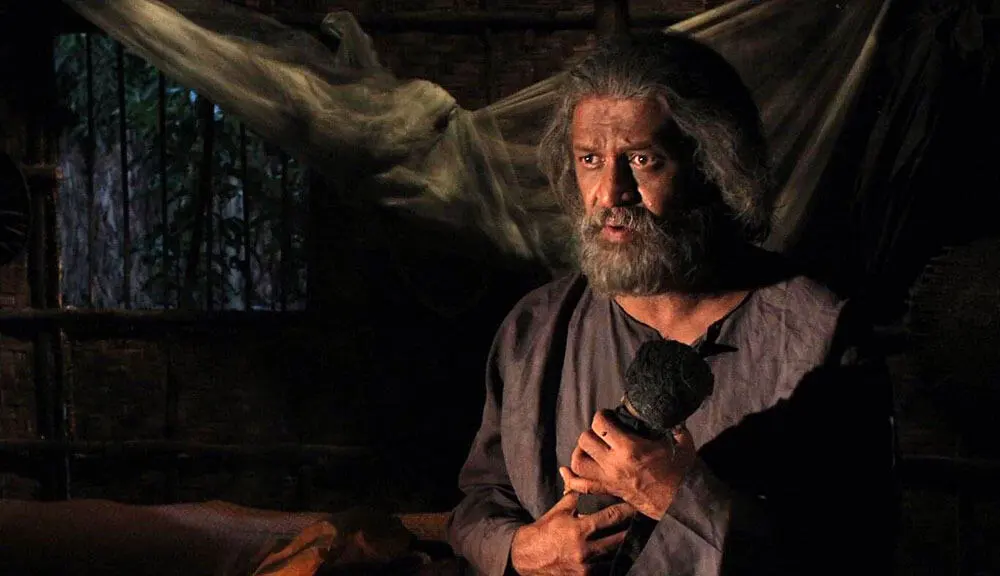 গাজী রাকায়েতের ‘দ্য গ্রেভ’ সিনেমার একটি দৃশ্য, যেখানে তিনি মাইক হাতে কথা বলছেন. Channel i News - চ্যানেল আই নিউজ