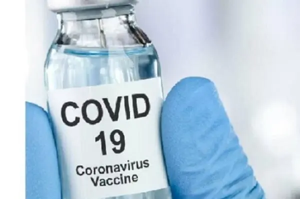 COVID-19 ভ্যাকসিনের বোতল হাতে গ্লাভস পরা স্বাস্থ্যকর্মী. Channel i News - চ্যানেল আই নিউজ