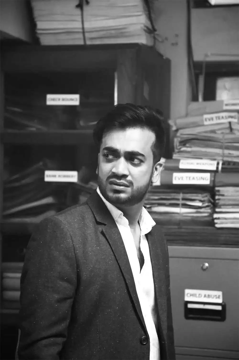 অফিসে একজন যুবক কর্মী, বই ও ফাইলের পেছনে দাঁড়িয়ে. Channel i News - চ্যানেল আই নিউজ