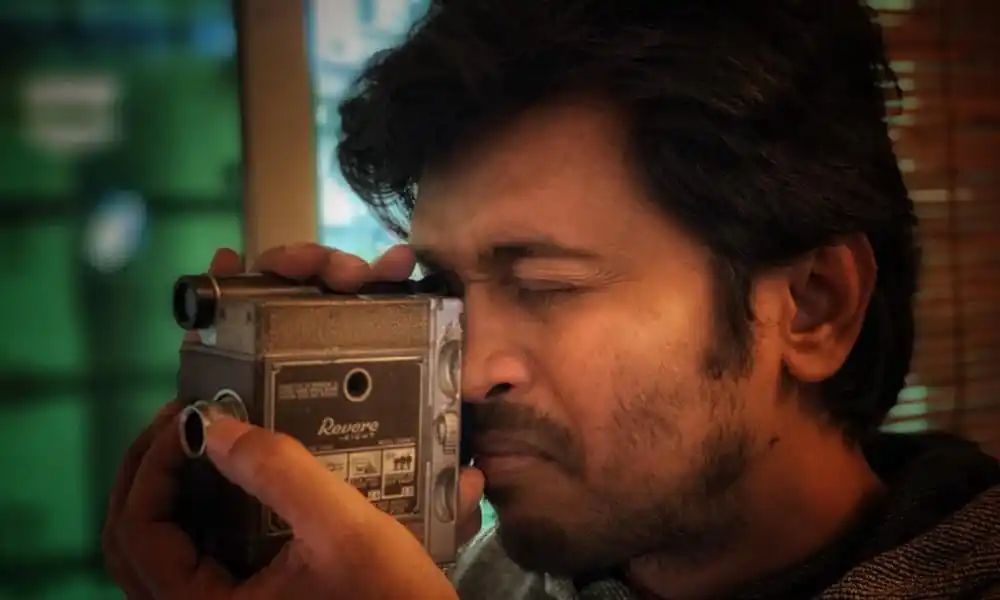 একজন ব্যক্তি ক্যামেরা দিয়ে ছবি তোলার চেষ্টা করছেন. Channel i News - চ্যানেল আই নিউজ