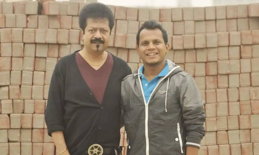 কুমার বিশ্বজিতের সঙ্গে একজন ভক্তের ছবি, উভয়ই হাসিমুখে দাঁড়িয়ে. Channel i News - চ্যানেল আই নিউজ