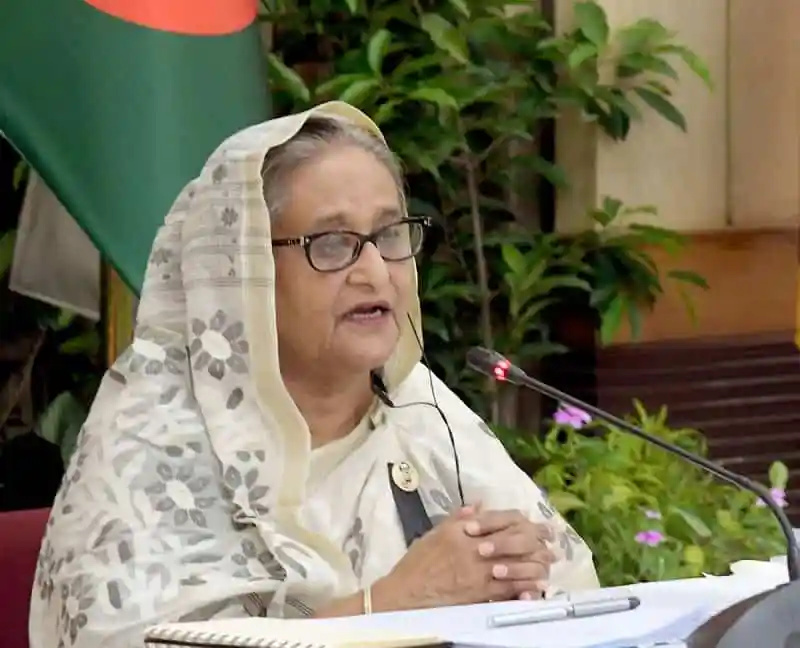 খালেদা জিয়া speaking at a press conference with Bangladesh flag in background. Channel i News - চ্যানেল আই নিউজ