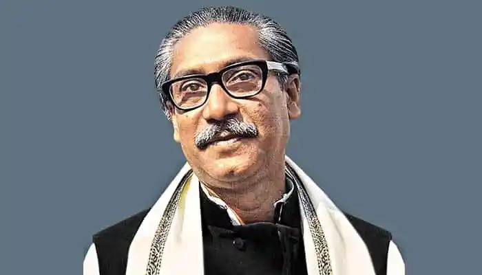 প্রধানমন্ত্রী শেখ হাসিনা হাস্যোজ্জ্বল মুখে, পটভূমিতে সাদা ও কালো পোশাক পরা. Channel i News - চ্যানেল আই নিউজ