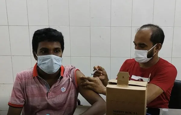 বাংলাদেশে গণভ্যাকসিন প্রদান কর্মসূচি চলাকালে একজন ব্যক্তি টিকা নিচ্ছেন. Channel i News - চ্যানেল আই নিউজ