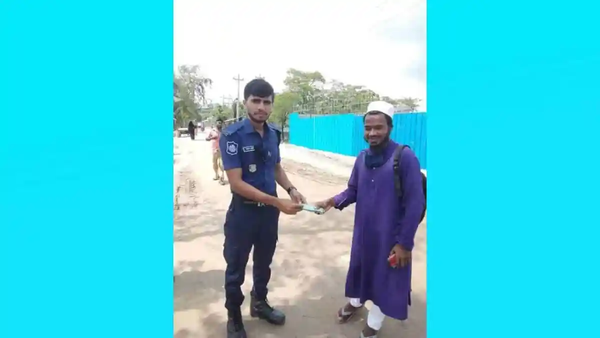 কনস্টেবল আল আমিন টাকা ফেরত দেওয়ার সময় একজন ব্যক্তির সাথে হাত মিলাচ্ছেন. Channel i News - চ্যানেল আই নিউজ