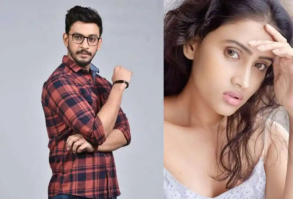 Young man with glasses and plaid shirt, woman with hand on forehead, looking stressed. Channel i News - চ্যানেল আই নিউজ