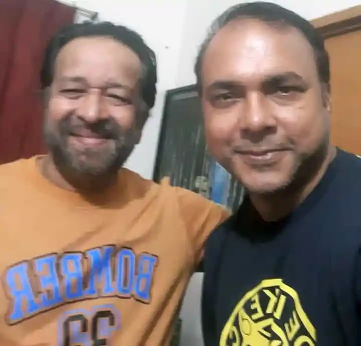 দুই বন্ধু হাসিমুখে ছবি তুলছেন, একজন বাম পাশে, অন্যজন ডান পাশে. Channel i News - চ্যানেল আই নিউজ