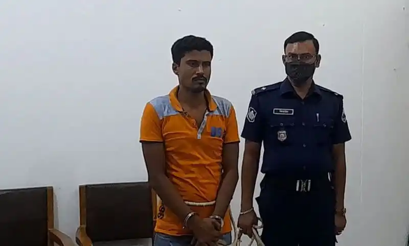 অভিযুক্ত ব্যক্তি পুলিশের সঙ্গে দাঁড়িয়ে, বাংলাদেশ. Channel i News - চ্যানেল আই নিউজ