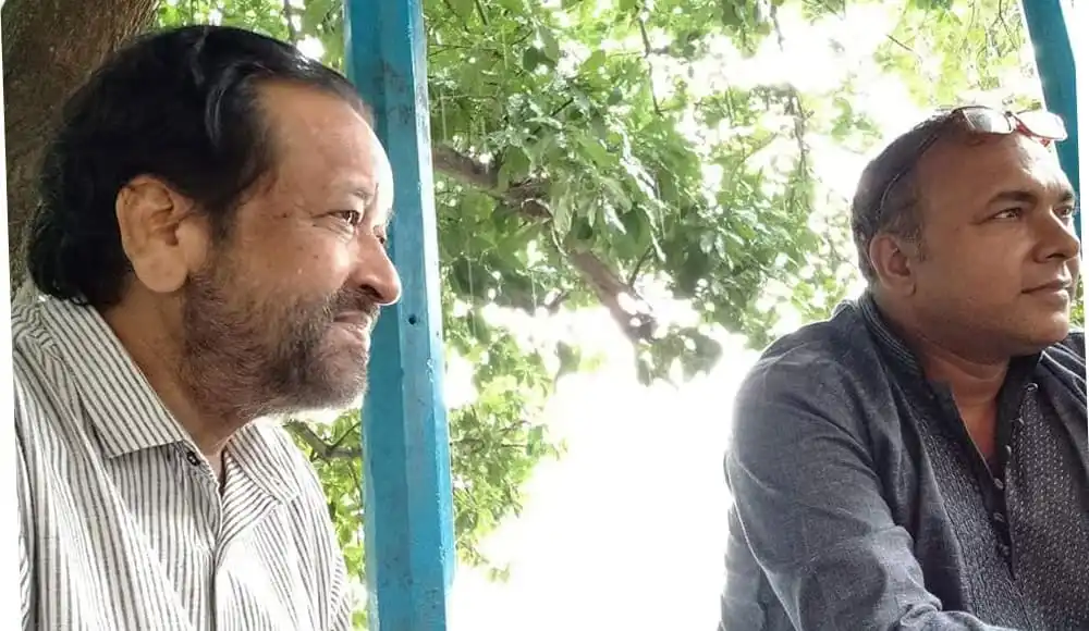 দুই ব্যক্তি একসঙ্গে বসে আলোচনা করছেন, প্রকৃতি পরিবেশে. Channel i News - চ্যানেল আই নিউজ