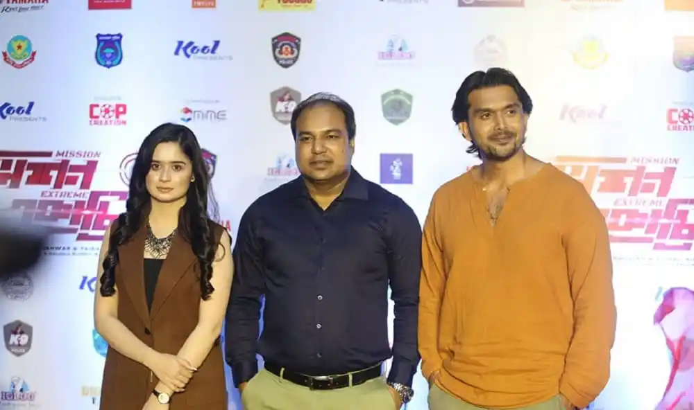 তিনজন ব্যক্তি ট্রেলার লঞ্চ অনুষ্ঠানে উপস্থিত, পেছনে ব্যানার ও লোগো. Channel i News - চ্যানেল আই নিউজ
