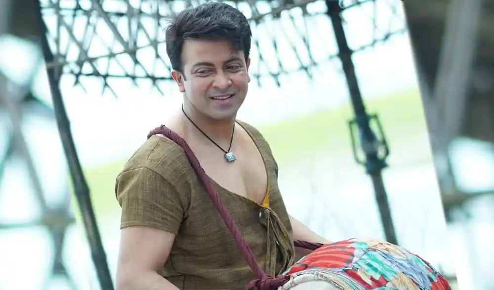 শাকিব খান গলুই সিনেমার চরিত্রে, হাসিমুখে ক্যামেরার দিকে তাকানো. Channel i News - চ্যানেল আই নিউজ