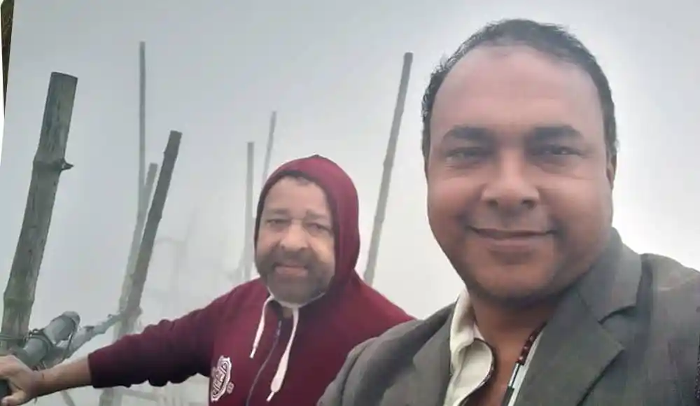 দুজন ব্যক্তি পাহাড়ের চূড়ায় দাঁড়িয়ে, ধোঁয়া ও মেঘের মাঝে. Channel i News - চ্যানেল আই নিউজ