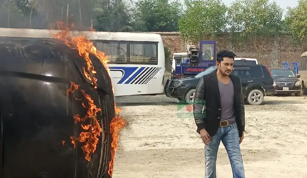 জ্বলন্ত গাড়ির পাশে দাঁড়িয়ে আছেন একজন ব্যক্তি. Channel i News - চ্যানেল আই নিউজ