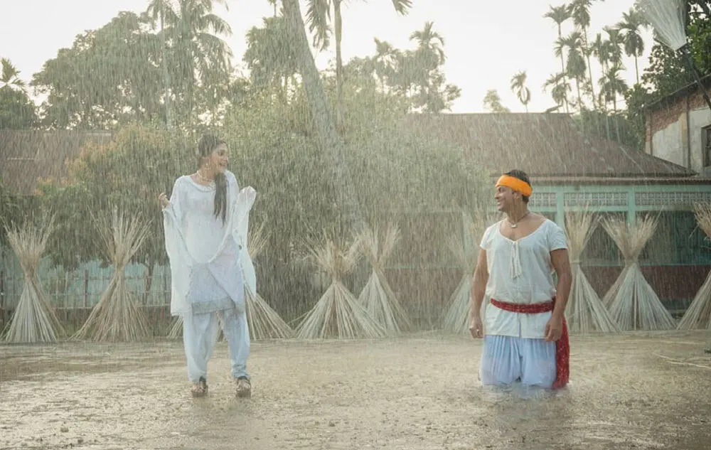 দুটি নারী বৃষ্টিতে খেলা করছে, এক নারী অন্যের দিকে তাকাচ্ছে।. Channel i News - চ্যানেল আই নিউজ