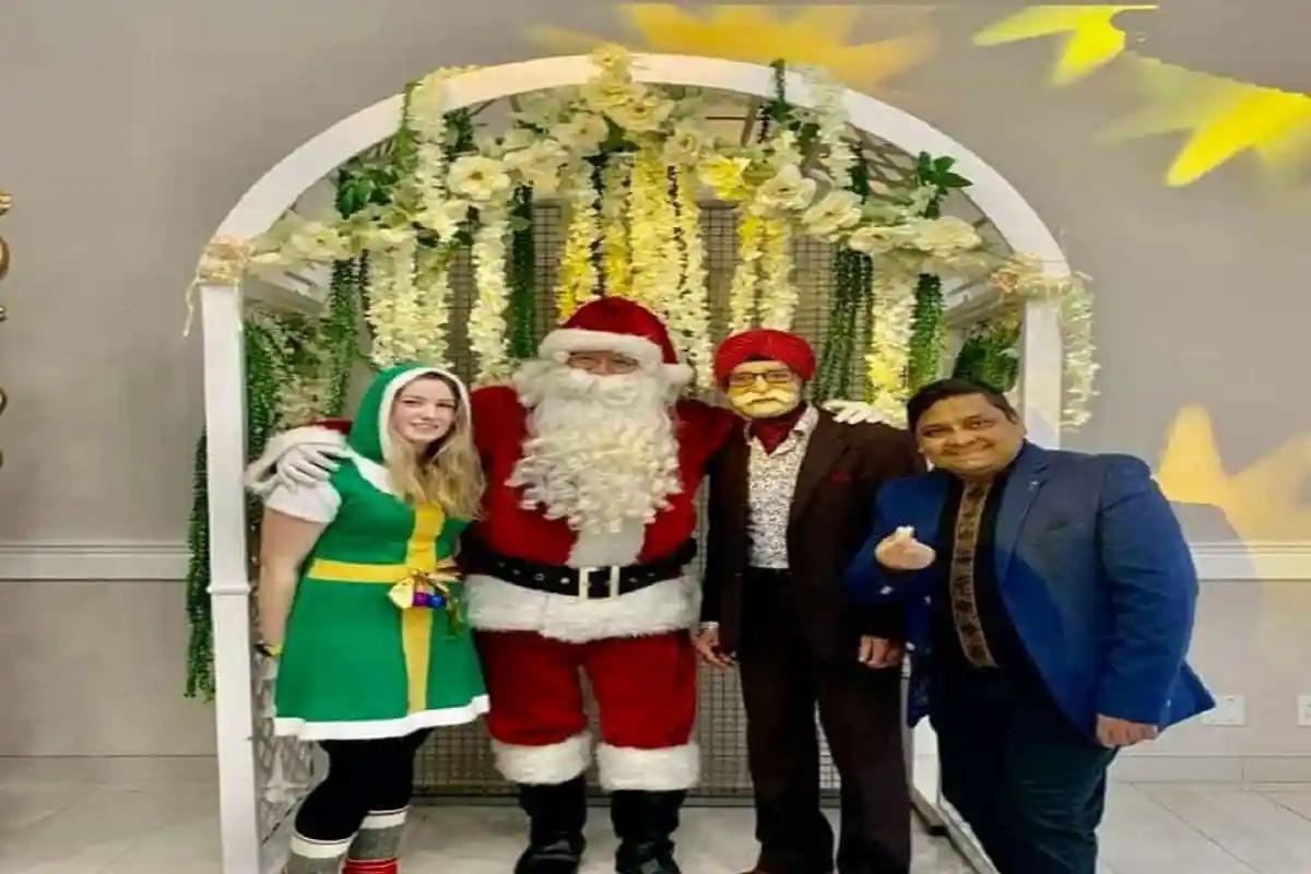 চারজন ব্যক্তি বড়দিনের সাজে, সান্তা ক্লাউসসহ, হাসিমুখে ছবি তুলছেন. Channel i News - চ্যানেল আই নিউজ