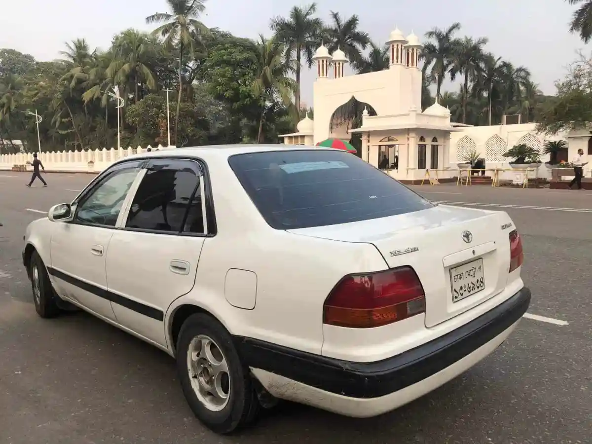 সাদা গাড়ি বঙ্গভবনের সামনে পার্ক করা, পেছনে গাছপালা ও ঐতিহ্যবাহী স্থাপনা. Channel i News - চ্যানেল আই নিউজ