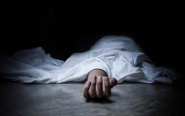 Dark image showing a hand lying on the ground in a dimly lit setting. Channel i News - চ্যানেল আই নিউজ