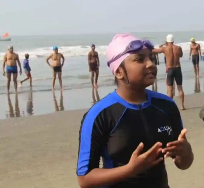 বালিকা সাঁতারু সৈকত ও সমুদ্রের পেছনে দাঁড়িয়ে. Channel i News - চ্যানেল আই নিউজ