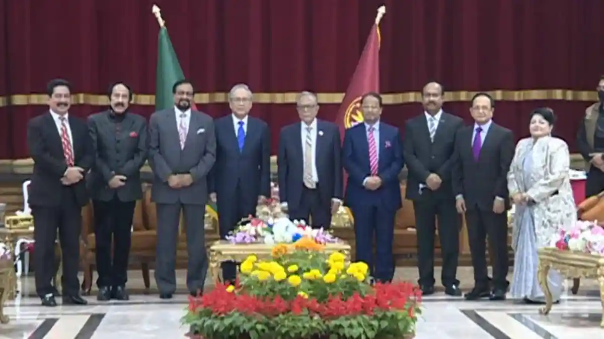 Bangladeshi and foreign officials at a formal event with flags in the background. Channel i News - চ্যানেল আই নিউজ